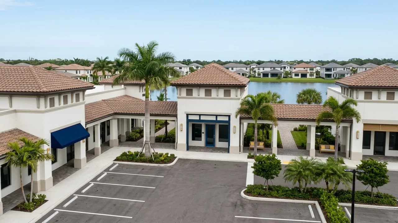 A tidy new neighborhood shopping plaza with palm trees, covered walkways and an empty parking lot near new homes in Southwest Florida, no store signs